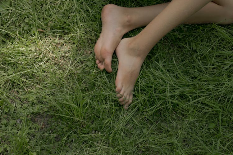 Bare Feet Laying On Green Grass