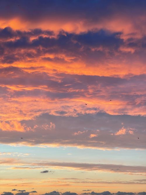 Free Stunning sunset with dramatic clouds and vibrant hues of orange and purple creating a breathtaking sky scenery. Stock Photo