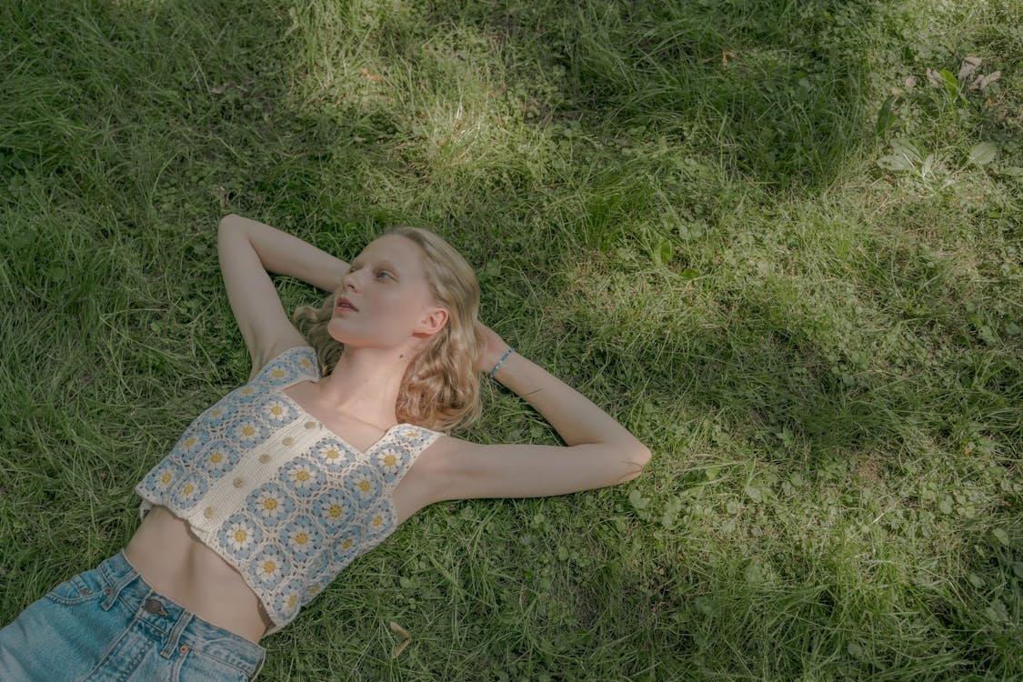 Blond Young Woman Laying on Lawn on Summer Sunny Day