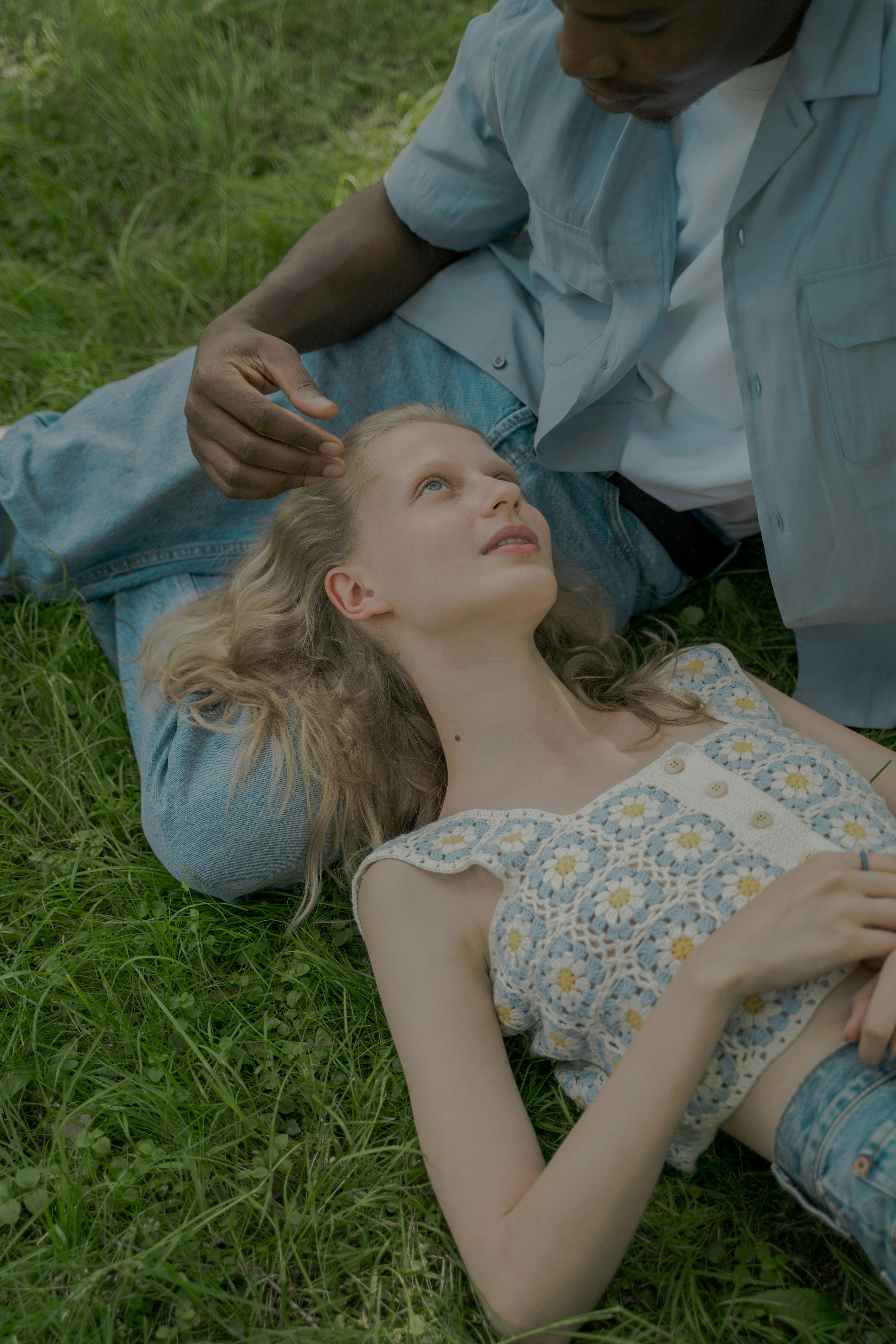 woman laying on mans knees on the grass