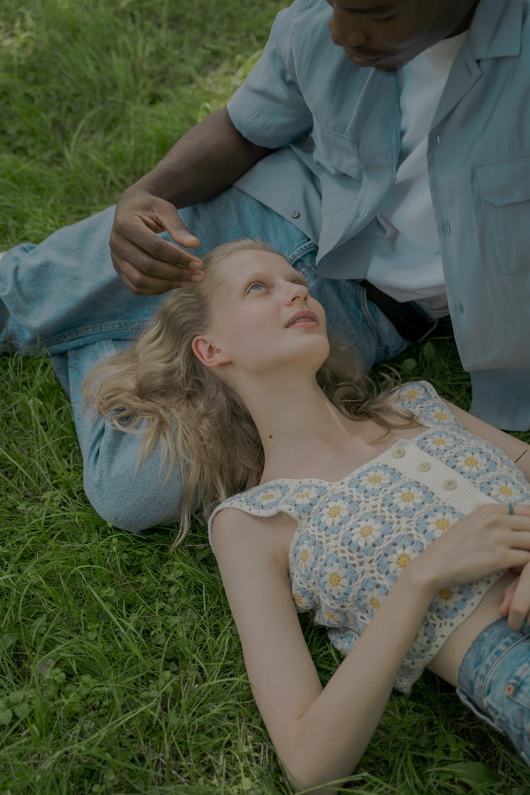 Woman Laying On Mans Knees On The Grass