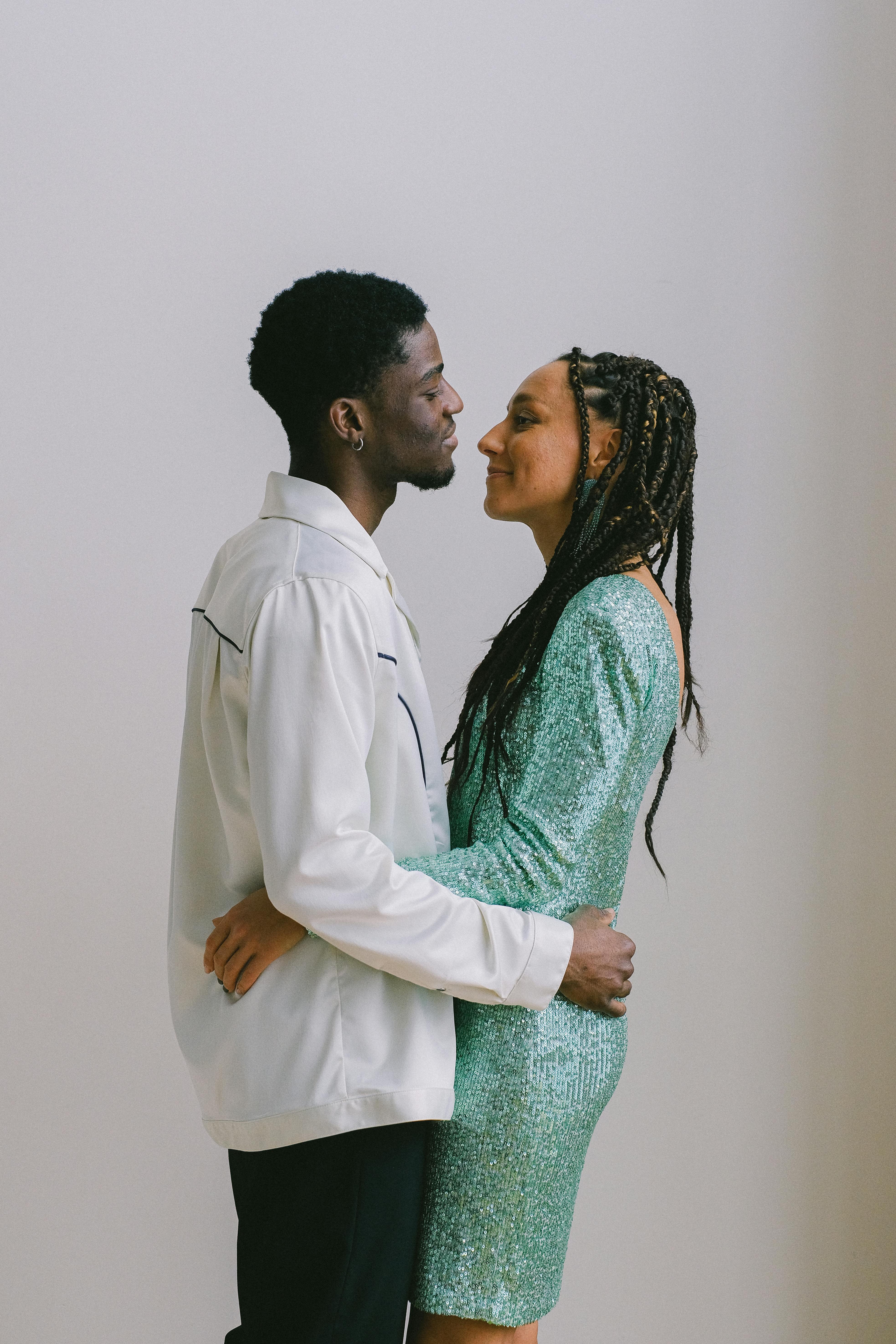 man in white long sleeve shirt facing a woman
