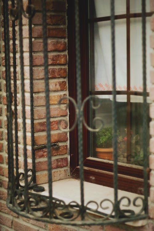 Free Metal Railing on a Glass Window and Brick Wall Stock Photo