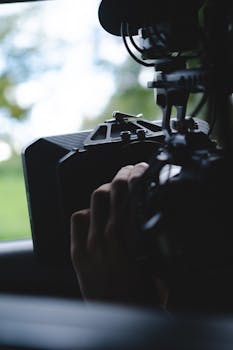 Close-up of a professional camera setup outdoors, highlighting videography equipment.