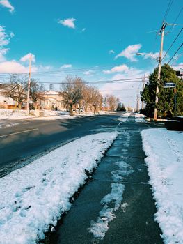 Snow-covered street in Toronto, Canada on a clear winter day with blue skies.