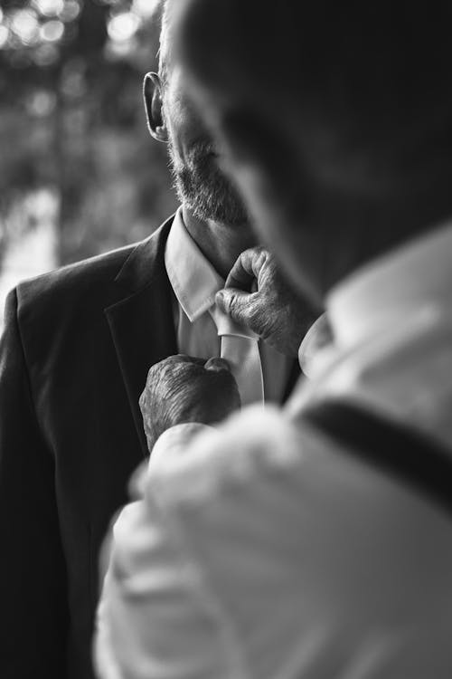 Man Helping Another with Necktie