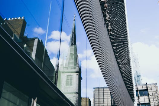 伦敦现代玻璃建筑立面上倒映着教堂的尖顶