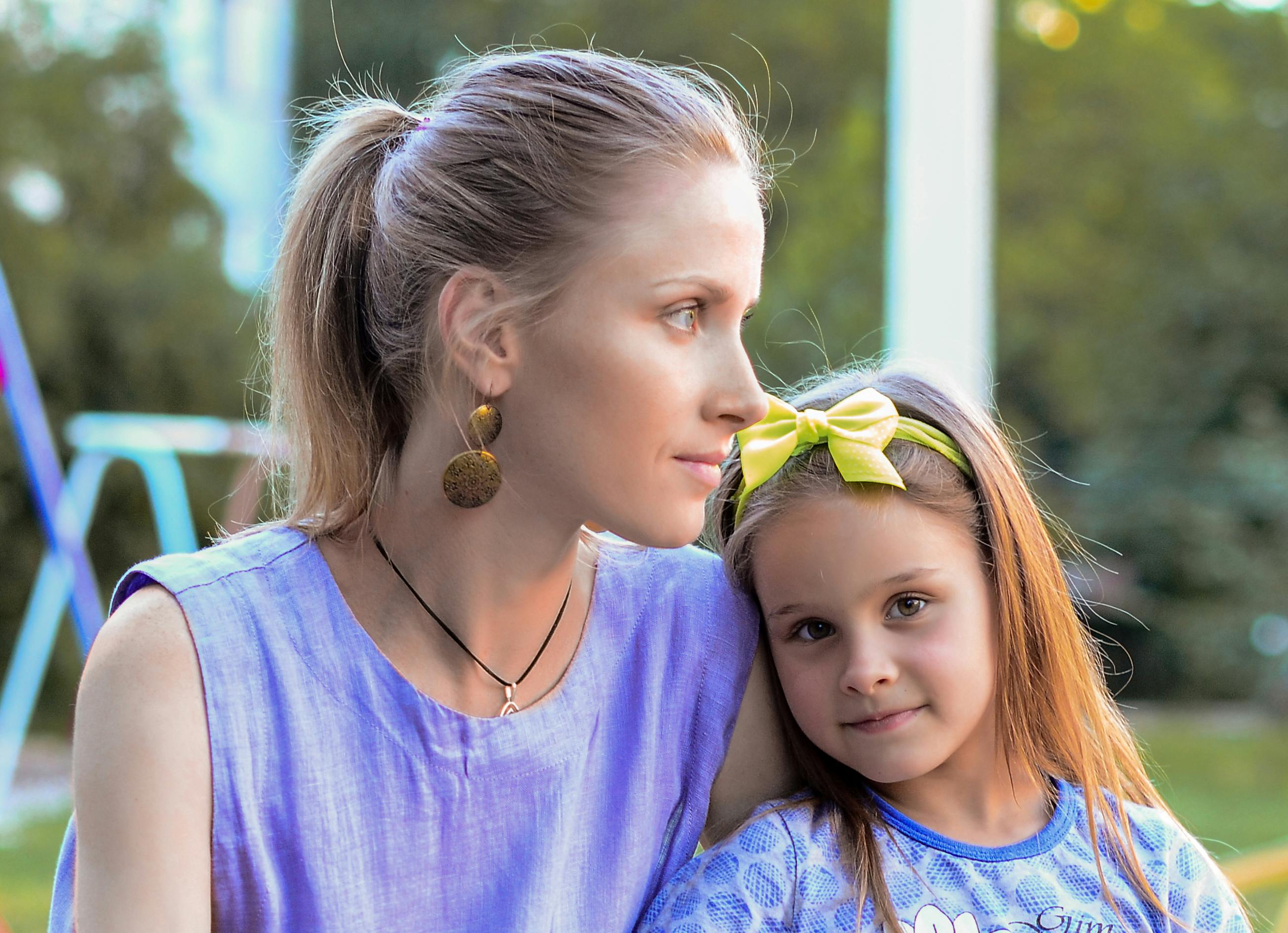 A warm moment shared between a mother and daughter outside.