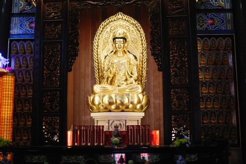 Free A detailed golden Buddha statue inside an ornate temple setting, showcasing intricate design and craftsmanship. Stock Photo