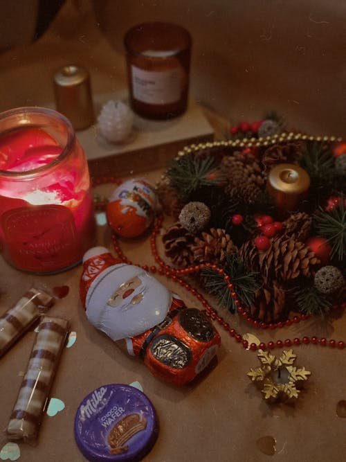 Christmas Decorations, Candles and Sweets Lying on a Table 