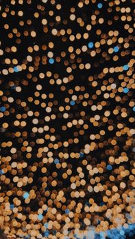 Abstract view of warm defocused festive lights, perfect for holiday and celebration themes.