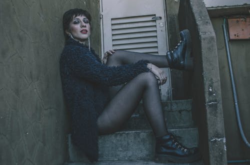 Free Woman in Black Fur Coat Sitting on Gray Concrete Stairs Stock Photo