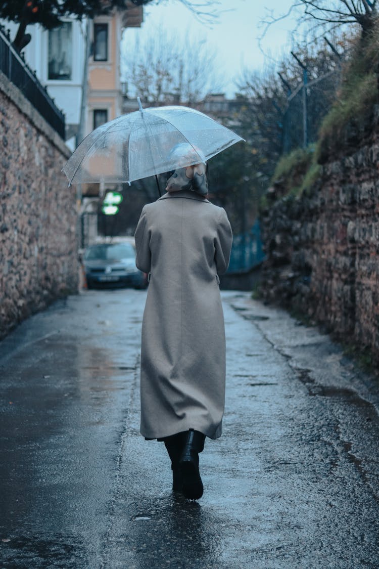 Woman With Umbrella Walking In Rain