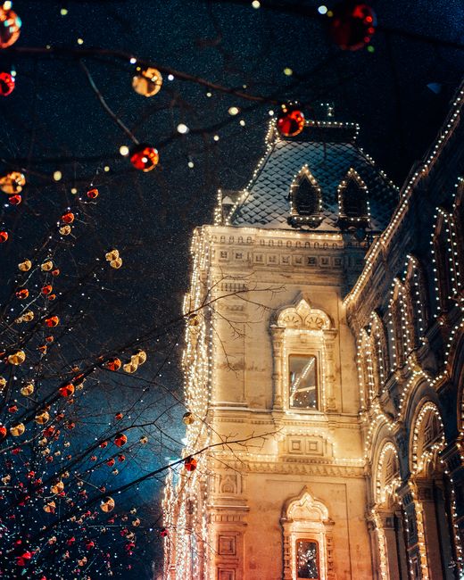 Illuminated building in Moscow adorned with festive lights at night, capturing holiday spirit.
