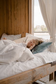 A young girl waking up in a cozy wooden bedroom with natural light streaming in.