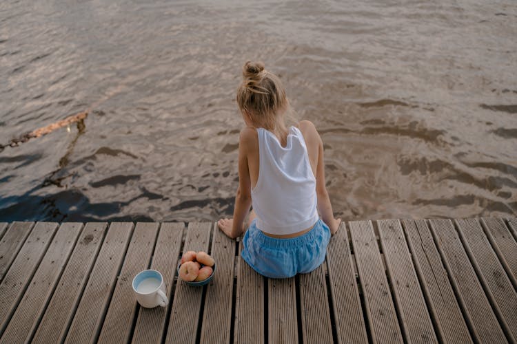 Child Sitting On Pier