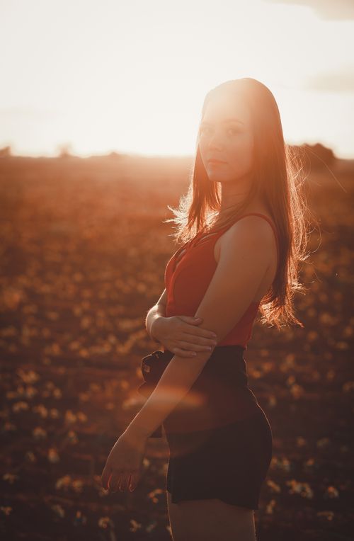 Free Striking portrait of a woman posing outdoors during a warm sunset. Stock Photo