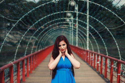 Woman in a Blue Dress Posing with Her Hands on Her Neck