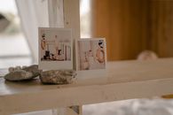 Charming home interior featuring polaroid photos and stones on a wooden shelf.