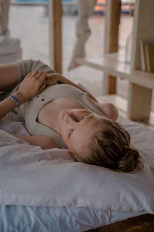 Free A woman with blond hair lying on a bed in a relaxed indoor setting. Stock Photo