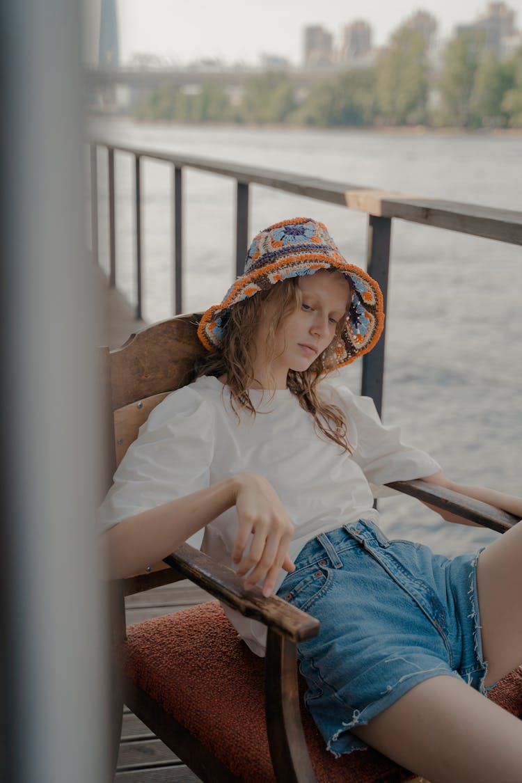 Woman Sitting In Chair On Pier