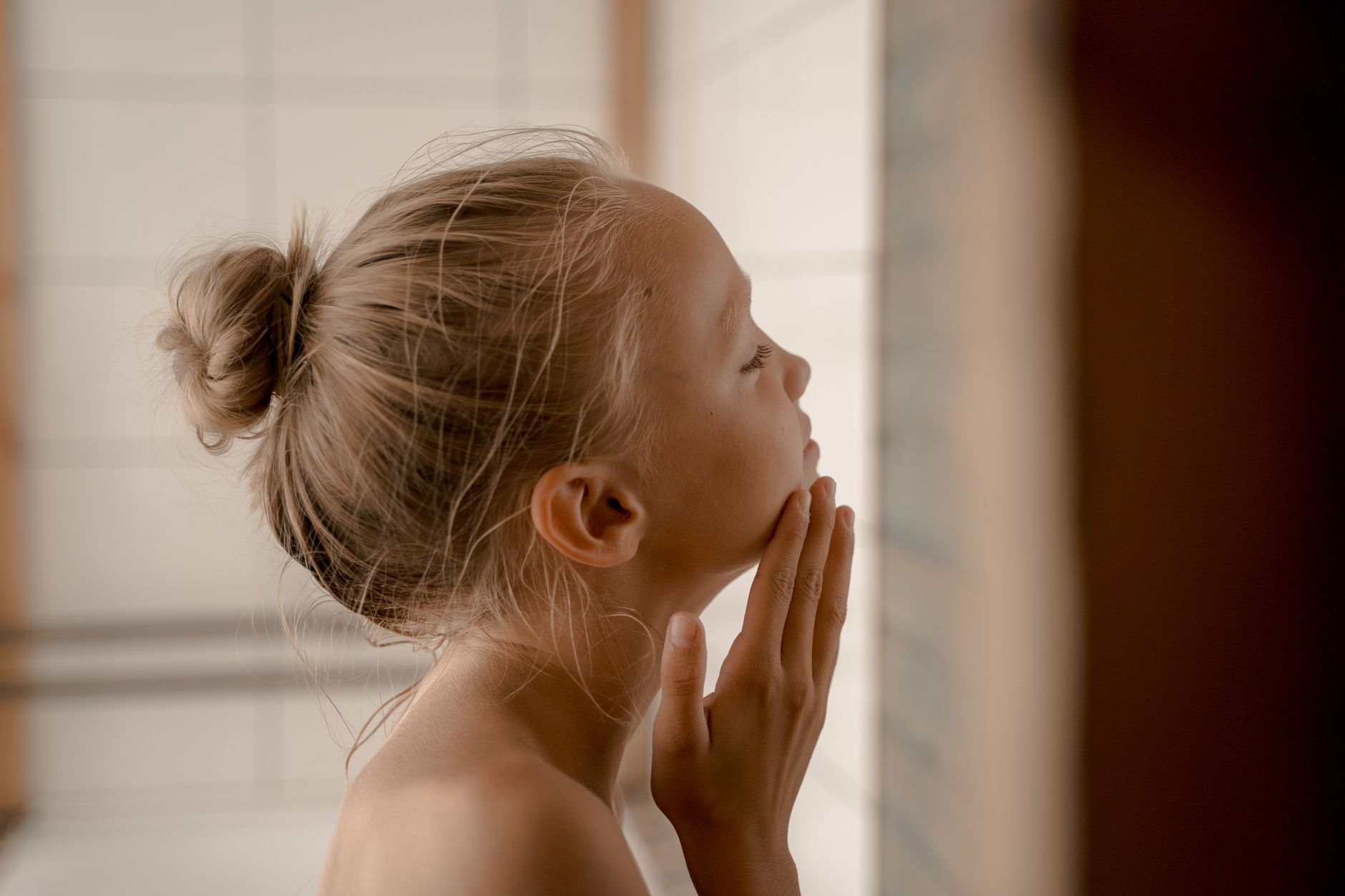 fille ado qui se regarde dans le miroir pour faire sa skincare