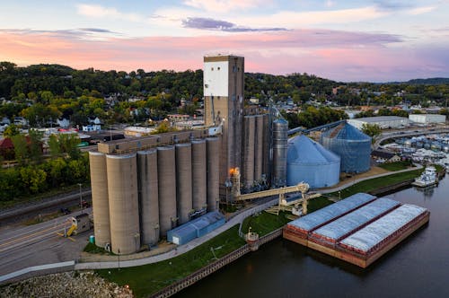 Aerial View of an Industry with Grain Elevators near a Reservoir 