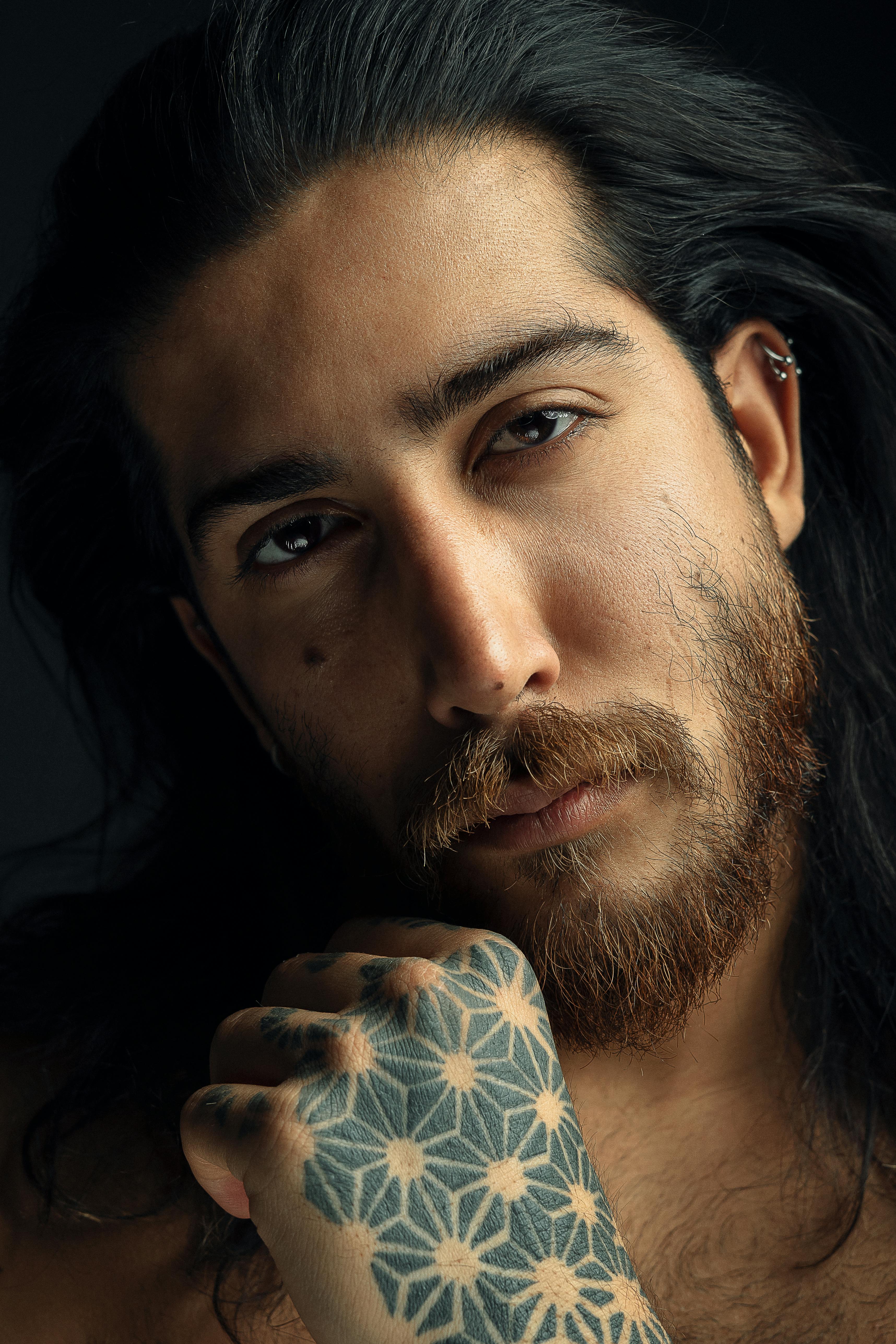 Premium Photo  Portrait of a guy with a beard and tattoos on a dark  background hipster