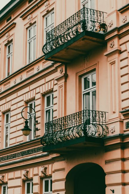 A classic architectural facade featuring ornate iron balconies and vintage streetlamp.