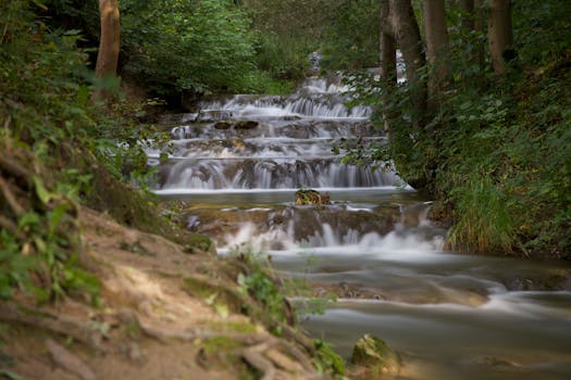 Serene cascading waterfall surrounded by lush forest in Lúčky, Slovakia.