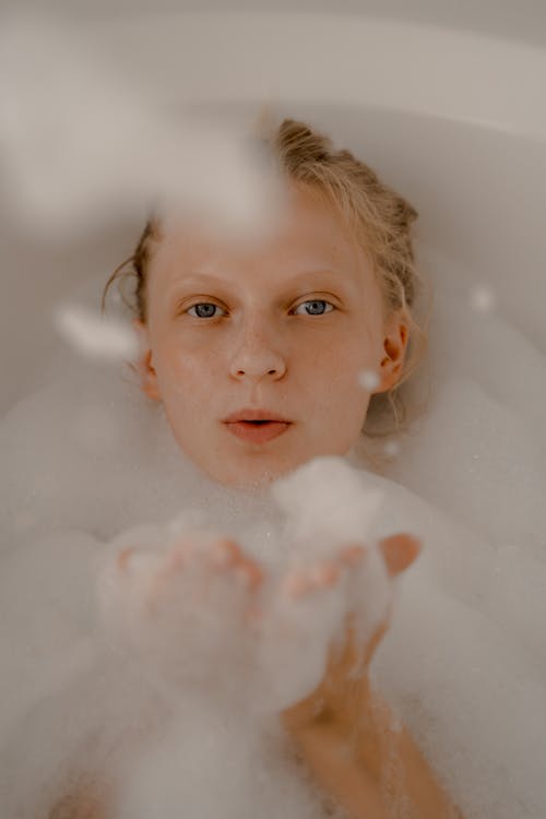 Woman Blowing Bubbles in Bathtub