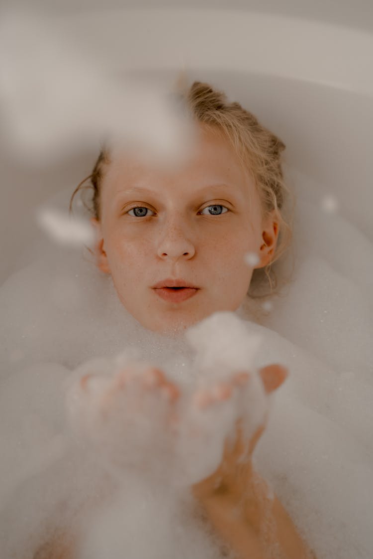 Woman Blowing Bubbles In Bathtub