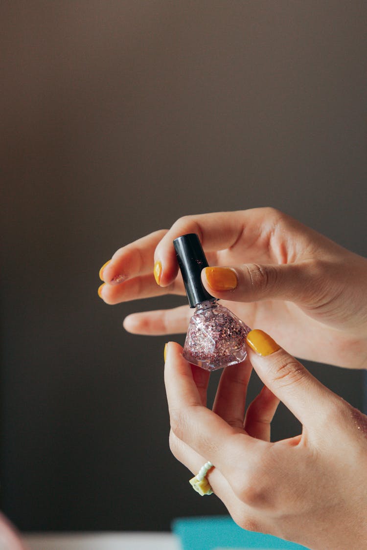 Person Holding Pink Nail Polish