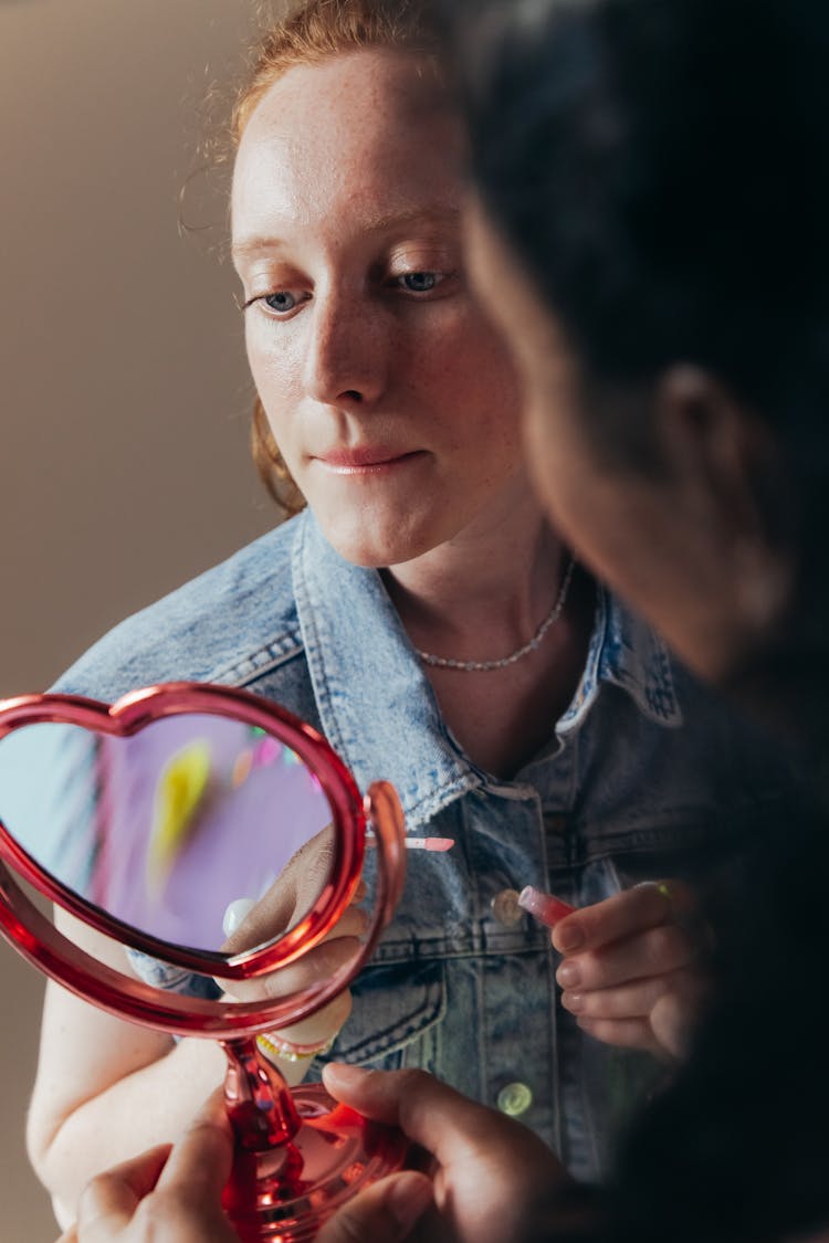 Woman In Denim Vest Looking At Mirror