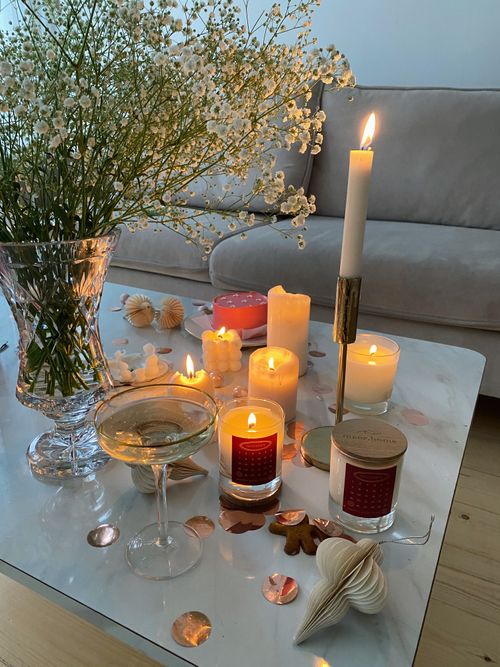 Free Elegant table setting with candles, a wine glass, and flowers creating a warm, inviting ambiance indoors. Stock Photo