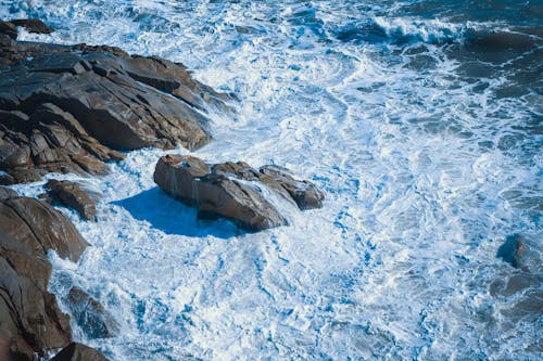Brown Rock Formation on Blue Sea Water