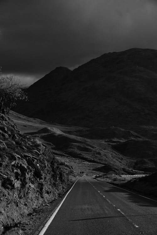 Grayscale Photo of Road Near Mountains