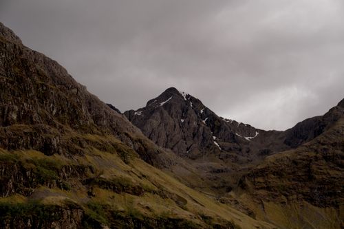 Free A rugged mountain peak with eroded rock formations beneath cloudy, overcast skies. Stock Photo