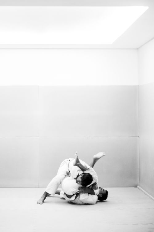 Free Two men practice martial arts in a minimalist indoor space. Stock Photo