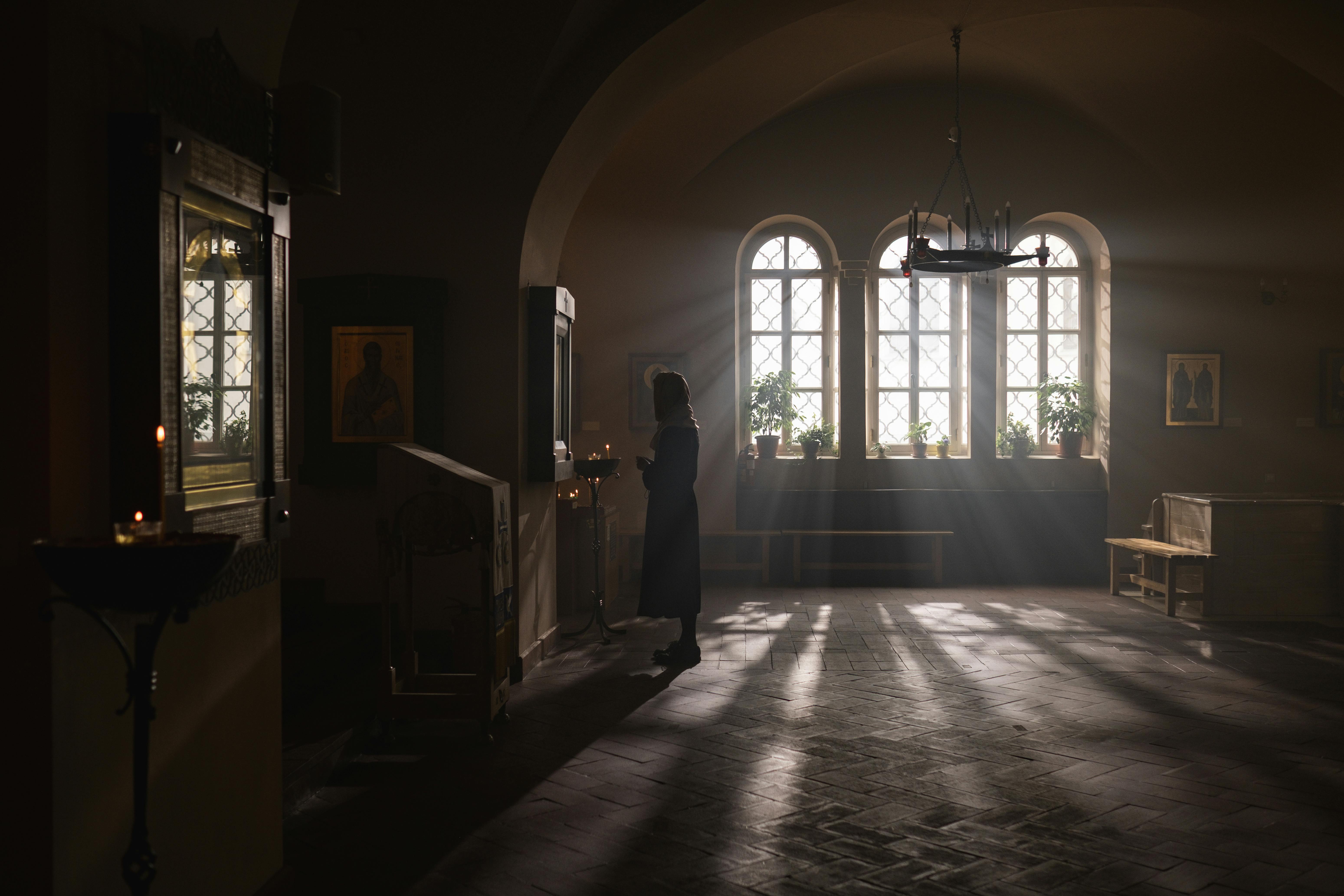 Lumină divină pătrunzând în biserică simbolizând deschiderea cerurilor