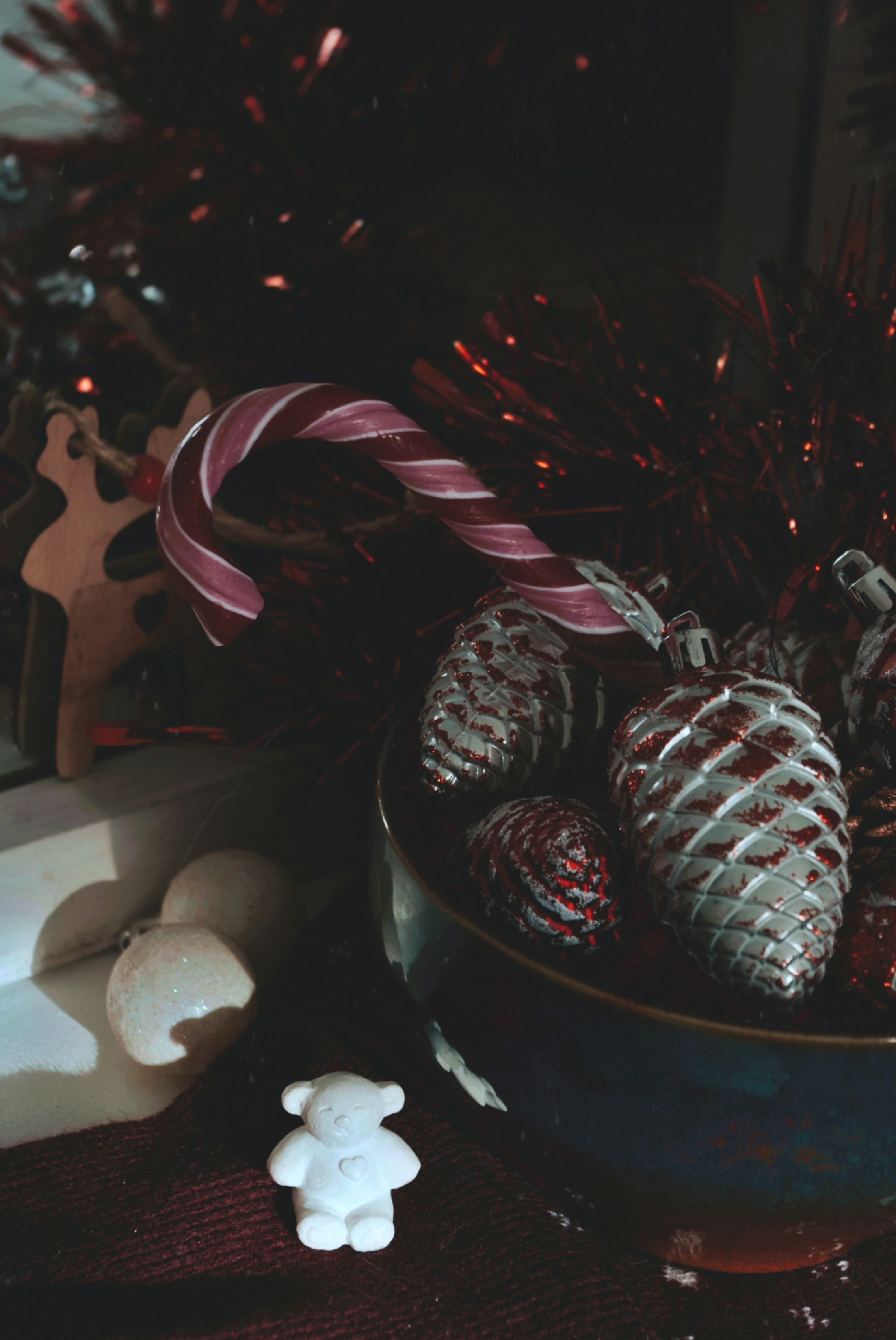 A cozy arrangement of Christmas baubles and candy cane in a bowl, perfect for festive decor.