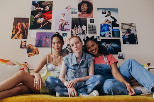 Three young women sitting together on a bed, showcasing diversity and friendship.