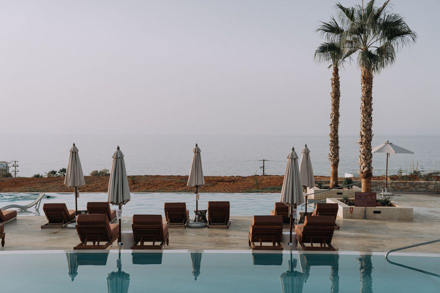 Sun loungers and parasols beside a resort pool overlooking the sea — photo by alleksana on Pexels