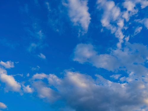 Free A captivating view of a vibrant blue sky filled with fluffy white clouds creating a serene atmosphere. Stock Photo