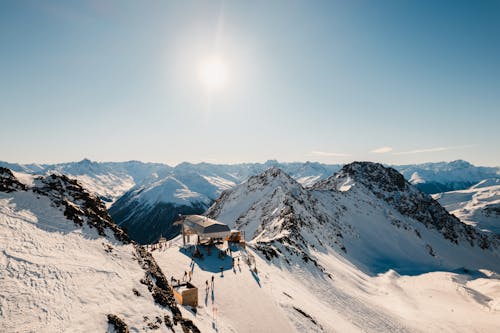 Sun Shining Over Snowcapped Mountain Range and Ski Lift