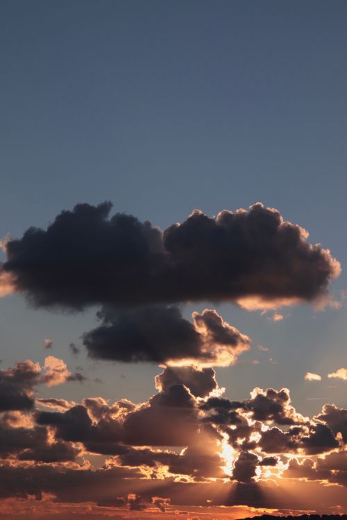 Free A stunning sunset captures deep clouds and warm hues in a vibrant sky. Stock Photo