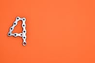 数字四的创意设计以橙色为背景，采用金属链构成，提供了充足的复制空间