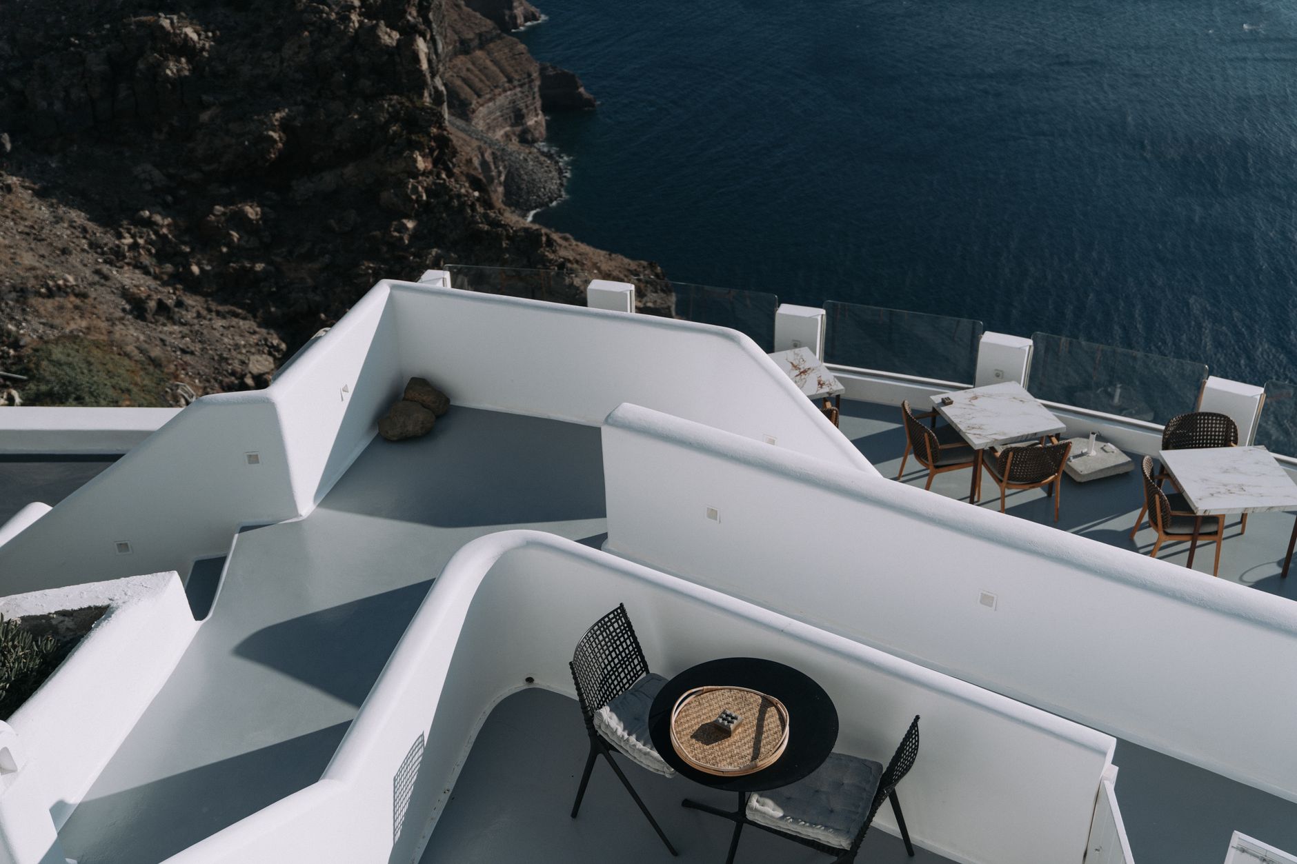 A serene and minimalist private luxury lounge overlooking a vast, untouched natural landscape under a twilight sky.