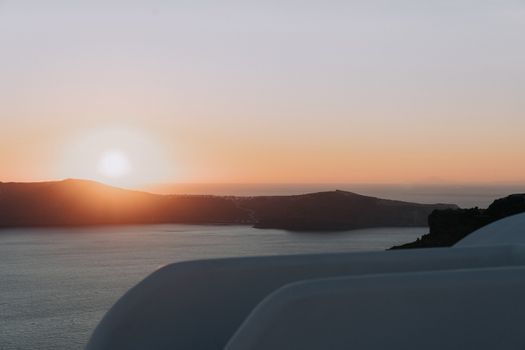 Serene sunset view over a calm sea and coastline, perfect for travel inspiration.