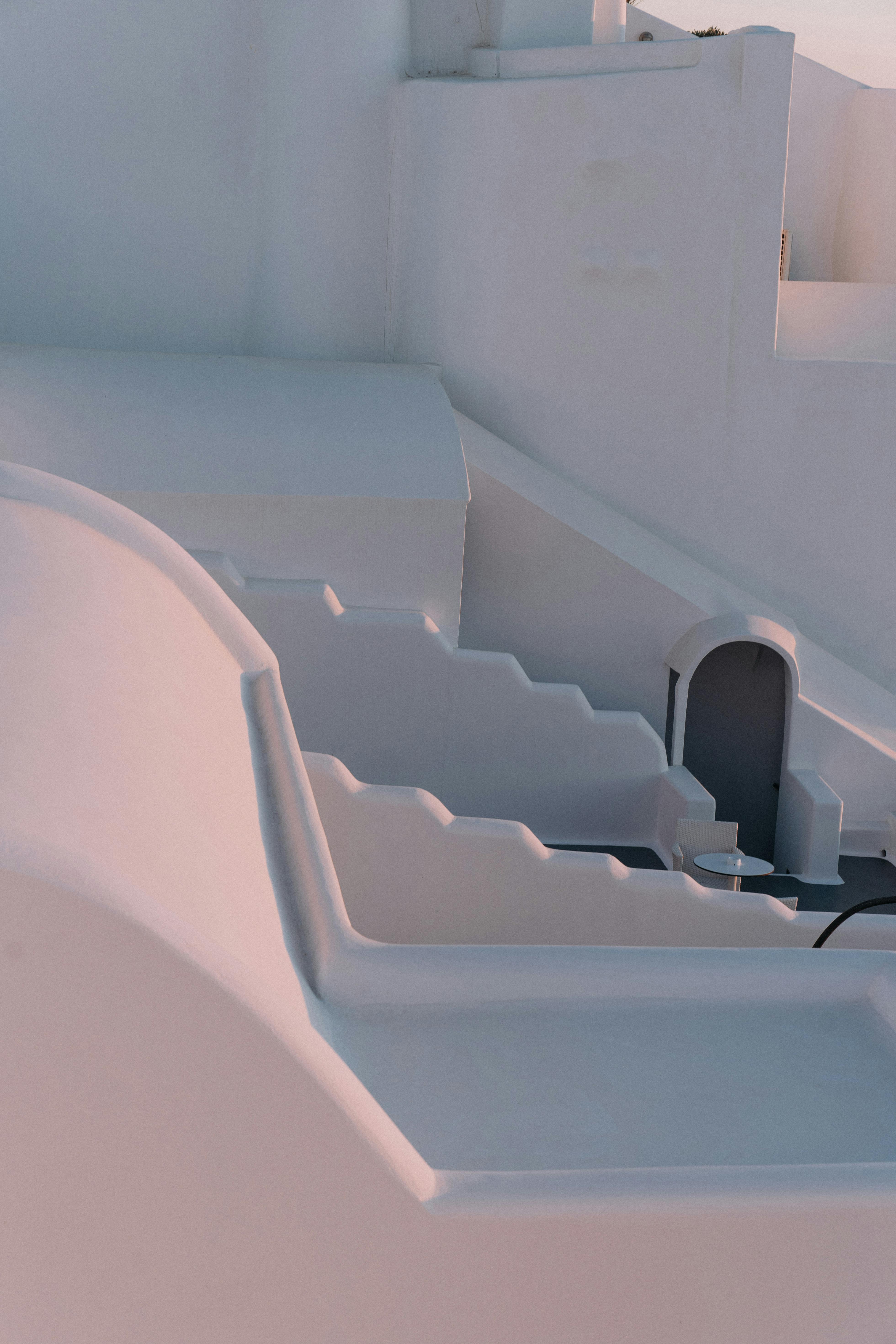 A serene view of white stucco architecture in soft sunlight, showcasing minimalist design.